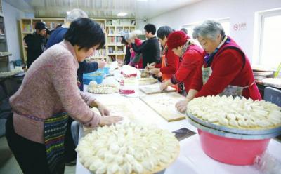 峪园社区的志愿者和社区干部为社区内离退休老人包饺子