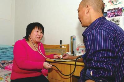 林凤秀在家里像大夫一样给丈夫量血压