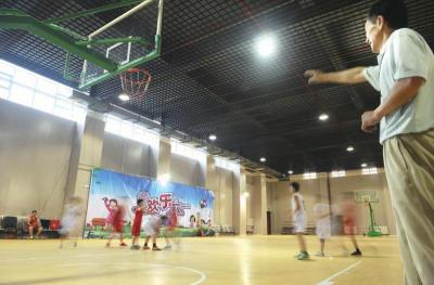 课余时间学生们在宽敞的体育馆里打篮球。