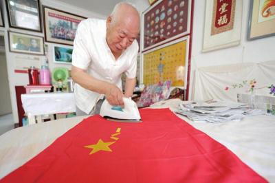 中国人民解放军“八·一”建军节快到了，崔学孟精心熨烫军旗。