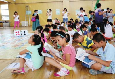 　　2014年7月31日，小学生正在阅读《门头沟法治季风》。