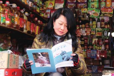 　　2013年3月15日，一名女店主正在认真阅读《门头沟法治季风》。