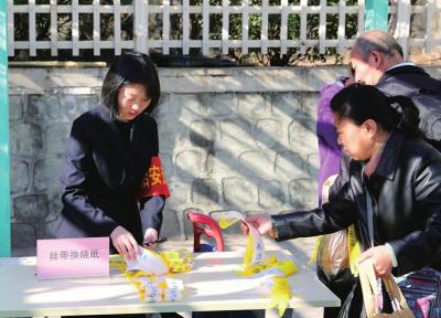 天山陵园的工作人员为前来祭扫的群众免费发放黄丝带