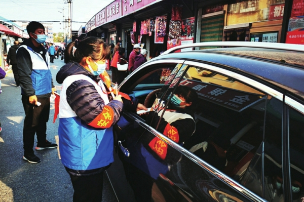 ——双峪菜市场工作人员为驾乘人员测量体温 ▲测温