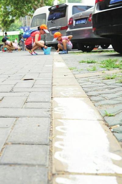 尽管地面喷涂小广告最难去除,但家长和孩子一起努力清理